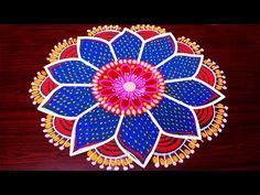 an intricately designed paper art work is displayed on a wooden table with red, blue and