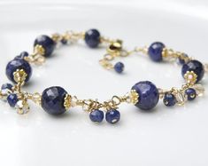 Gorgeous sapphire bracelet features genuine sapphire gemstones finely faceted for added sparkle. Swarovski crystals in champagne and more real sapphire gemstones dangles to add movement to this luxe artisan bracelet. 14k gold filled findings. Give a precious gift to a beautiful woman born in September since sapphire is her birthstone. Dressy bracelet can be worn to formals, events and everyday.Bracelet Details:- Bracelet is 7 to 8.5 inches long (17.78 cm to 20.32 cm)- A built in extender to all Elegant Sapphire Bracelets With Faceted Beads, Elegant Sapphire Bracelet With Faceted Beads, Elegant Sapphire Beaded Bracelets With Round Beads, Elegant Sapphire Beaded Bracelets, Sapphire Rondelle Jewelry For Gift, Sapphire Rondelle Jewelry Gift, Elegant Sapphire Faceted Bracelets, Elegant Gemstone Beaded Bracelets For Anniversary, Elegant Crystal Bracelet With Birthstone For Anniversary