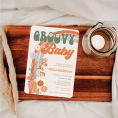 a wooden tray with a baby book and candle on it