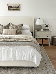 a bed with white linens and pillows in a bedroom