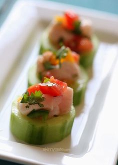 small cucumbers with various toppings on a white plate