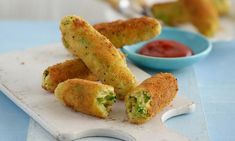 some fried food on a cutting board with dipping sauce