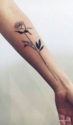 a woman's arm with a rose tattoo on it