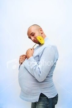 a man with a flower in his mouth is holding on to the back of his stomach