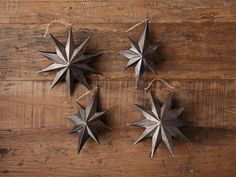 three metal stars hanging from string on wooden surface