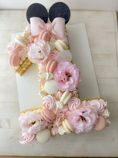 a cake decorated with pink flowers and mickey mouse ears