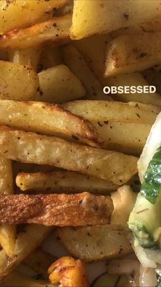 a close up of french fries on a plate with cheese and spinach toppings