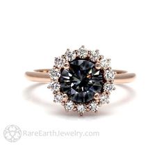 an engagement ring with a black diamond surrounded by white and rose gold diamonds, on a white background