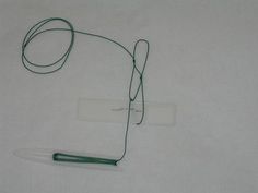 a green string attached to a white piece of paper