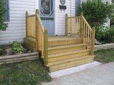 a wooden porch with steps leading up to the front door