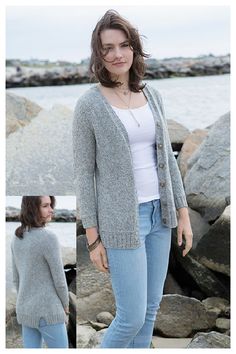 a woman standing on some rocks by the water with her hands in her pockets and looking at the camera