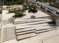 an aerial view of a parking lot with stairs leading up to it and cars parked in the background