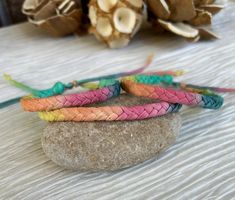 four bracelets sitting on top of a rock