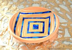 an orange and blue bowl sitting on top of a table