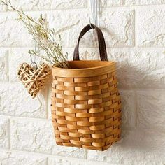 a basket hanging on the wall with a plant in it