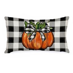 a black and white checkered pillow with a pumpkin painted on the front, tied in a bow