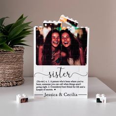 a photo frame sitting on top of a table next to candles and a potted plant