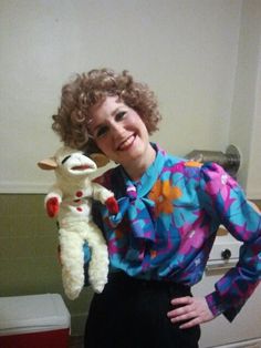 a woman is holding a stuffed animal in her hand and smiling at the camera while wearing a colorful shirt