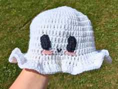 a crocheted white hat with two black eyes