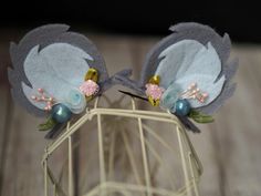 two gray and white birds with flowers on their ears