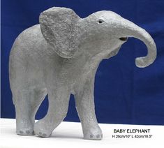 a baby elephant statue is shown against a blue background