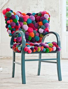 an image of a chair made out of pom poms and yarns on the floor