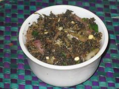 a white bowl filled with food sitting on top of a blue and purple table cloth