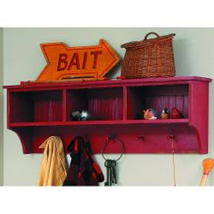 a red shelf that has some items on top of it and a sign above it