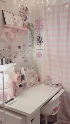 a white desk topped with a laptop computer next to a pink wall mounted light fixture