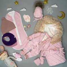 baby clothes and accessories laid out on a table with stars, moon, and other items