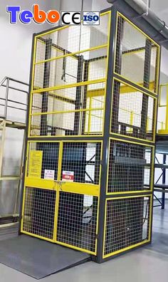 a large yellow cage is in the middle of a warehouse