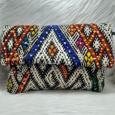 Berber Kilim Clutch Bag made in Morocco with detachable chain 11.8 x 7.4 IN Awesome clutch bag handmade from vintage Berber Kilim rugs, and coming straight from Morocco. Its geometric patterns, its tassels and its attractive colors give it a bohemian and trendy look. Sure, it will be a major piece of your outfit! Its detachable chain will allow you to carry it as a clutch bag or as a handbag. Very practical! It contains an inner pocket to hide your most precious objects. In short, it is an authentic piece and especially unique! Closing system: a flap, a zipper and 2 snaps. The imperfections that you may find on this piece guarantee its real handicraft manufacture and add to its charm. *Approximate dimensions (length x width): 30x19 cm / 11.81x7.5" IN *Length of the chain: 120 cm / 47.2" *M Rectangular Clutch With Removable Pouch, Fashion Clutch Pouch For Mobile Phone, Multicolor Envelope Bag For Everyday Use, Multicolor Clutch Mobile Phone Bag, Multicolor Clutch With Mobile Phone Bag, Multicolor Evening Clutch With Removable Pouch, Multicolor Mobile Phone Pouch, Multicolor Pouch Evening Bag With Removable Pouch, Multicolor Evening Bag With Removable Pouch