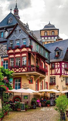 an old building with many windows and balconies on the top floor is surrounded by greenery