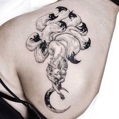 a woman's back with an artistic tattoo design on it