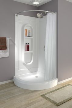 a bathroom with a shower, toilet and rug on the floor