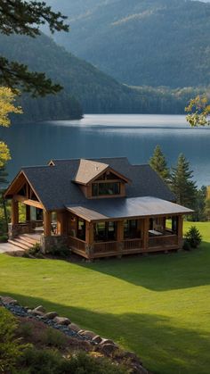 a large house sitting in the middle of a lush green field next to a lake