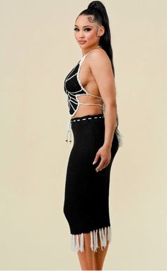 a woman in a black and white outfit posing for the camera with her hands on her hips