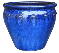 a large blue pot with metal handles and knobs on the sides, sitting in front of a white background