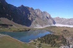 an aerial view of a lake surrounded by mountains