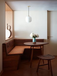 a small table with flowers in a vase on top of it next to a bench