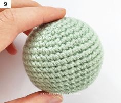 a crocheted ball being held by someone's hand