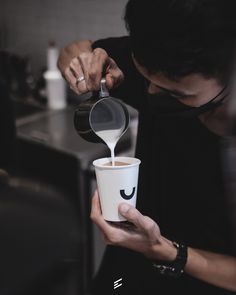 a person pouring coffee into a cup