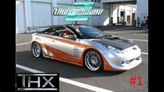 an orange and silver sports car parked in front of a building