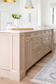 a large kitchen with wooden cabinets and white counter tops, along with a rug on the floor