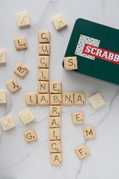 scrabbles are scattered around the word scramble on a marble surface with a green box