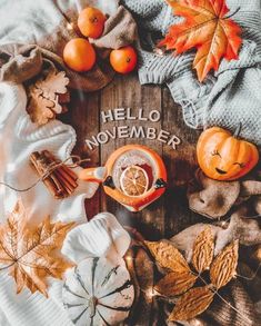 the words hello november are surrounded by autumn leaves, pumpkins and acorns