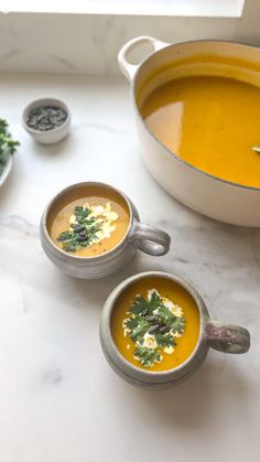 two bowls of soup are sitting on a counter