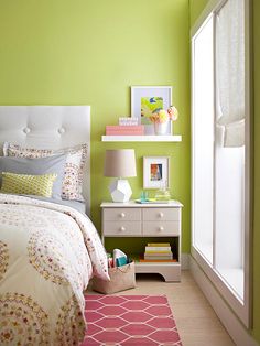 a bedroom with green walls and white furniture