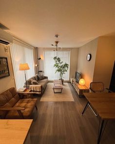 a living room filled with furniture and a flat screen tv on top of a wooden table