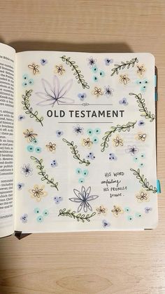 an open bible with flowers and vines on it